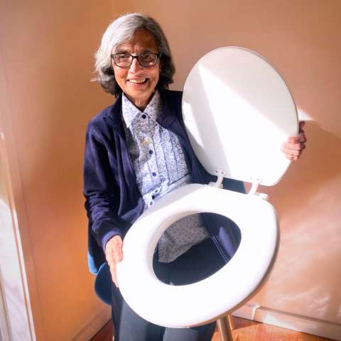 A person holding a Padded Toilet Seat